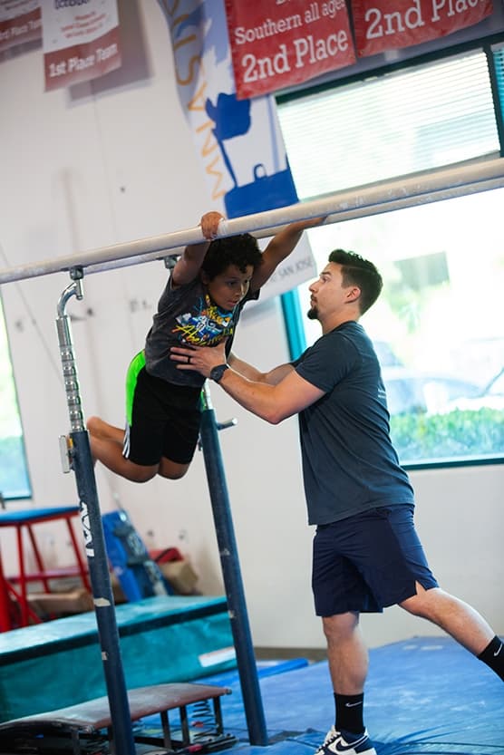 boy swinging parallel bars